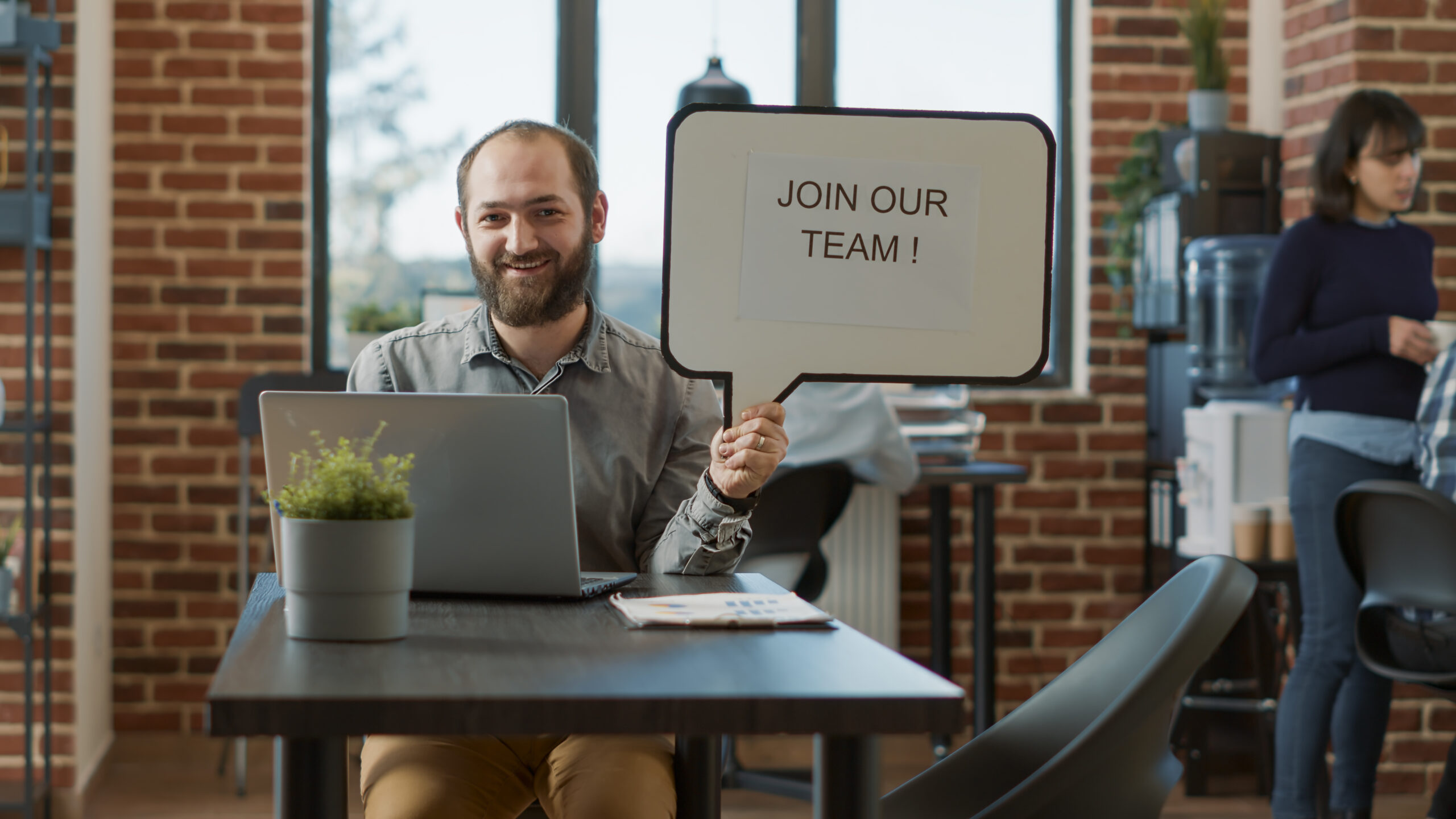 Portrait of cheerful man pointing at speech bubble with hiring ad, making job and employment offer. Positive male recruiter advertising HR work application opportunity with text message.